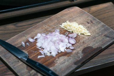 Tahtada bıçakla ince ince doğranmış soğan.