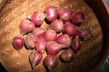 Endonezya mutfağını çeşnilendirmek için taze soğanları rattan bir sepete koy.