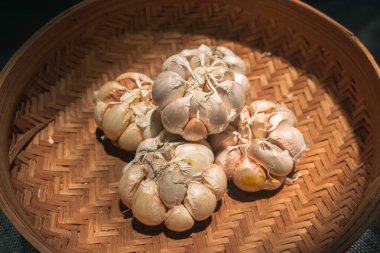 Arka plandaki sarımsağı kapat. Hasır sepette sarımsak