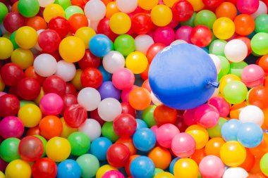 Canlı bir balon arka plan dizisi karnaval benzeri bir atmosferle görüntüyü aydınlatıyor. Renkleri farklı, havuzun üzerinde yüzüyor.
