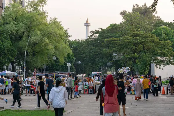 Jakarta, Endonezya 7 Temmuz 2023. Arkadaşlar ve aile Taman Lapangan Banteng 'de pikniğin tadını çıkarıyorlar.
