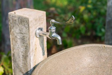 Parkta taştan yapılmış dış su musluğu.