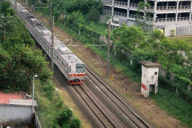 Kereta Api Endonezya Kereta Listrik Pondok Çin istasyonundan geçen Elektrikli Yolcu: Depok, Endonezya - 3 Eylül 2023