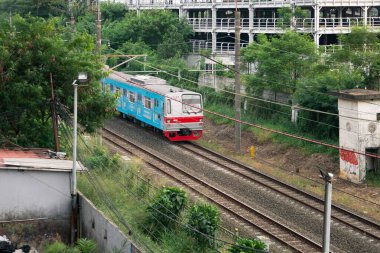 Kereta Api Endonezya Kereta Listrik Pondok Çin istasyonundan geçen Elektrikli Yolcu: Depok, Endonezya - 3 Eylül 2023