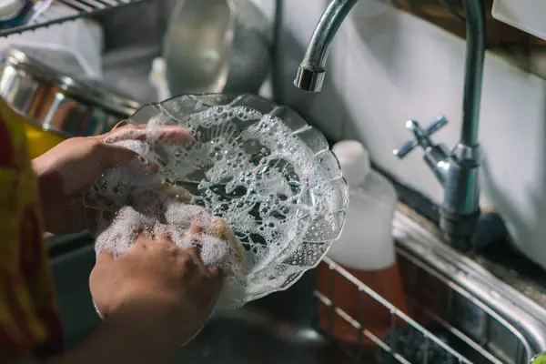 Mutfakta bulaşık yıkayan kadınların ellerini kapat. Modern bir mutfakta bulaşıkçı kullanmak. Doğal Temiz Diyet ve Sağlıklı Yaşam Konsepti.