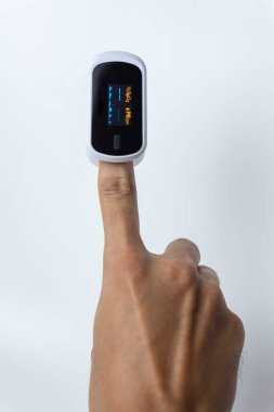 Beyaz arkaplanda izole edilmiş Nabız Oksimetrisi kullanırken insan parmağını kapat.