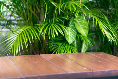 Ürün sunumu için boş gösteri. Tahta tablolar ve alanlar tropikal yapraklarla kuruludur..