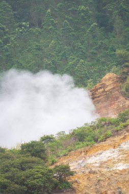 Dieng, Endonezya 'daki Sikidang kraterinin manzarasında sülfür dumanı var. Sülfür dumanlı bir dağda güzel manzara