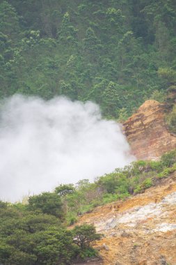 Landscape of Sikidang crater in Dieng, Indonesia with smoke of sulfur. Beautiful scenic in a mountain with sulfur smoke clipart