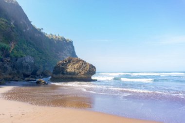İnsansız, berrak gökyüzü ve mavi okyanusla çarpıcı bir kıyı manzarası. En iyi tatil gezisi