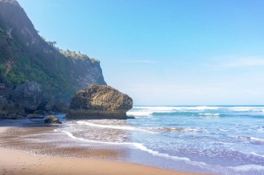 İnsansız, berrak gökyüzü ve mavi okyanusla çarpıcı bir kıyı manzarası. En iyi tatil gezisi