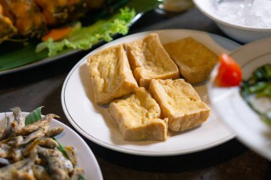Tahu goreng ya da kızarmış soya peyniri beyaz tabakta hazırlanır. Asya yemekleri ve Endonezya yerel yemekleri.