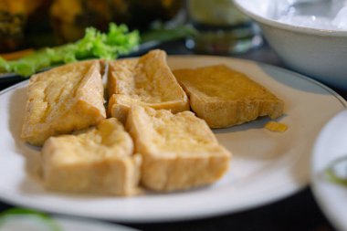 Tahu goreng ya da kızarmış soya peyniri beyaz tabakta hazırlanır. Asya yemekleri ve Endonezya yerel yemekleri.