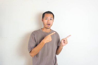 Genç Yetişkin Asyalı erkekler gülümseyerek sağı işaret ediyor. 