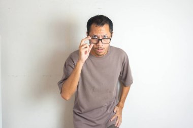 Genç Asyalı sakallı adamlar gözlüğünü indiriyor. Şaşırtıcı duygularıyla, izole beyaz arka planda.