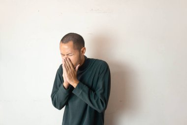 Genç Asyalıların ateşi olur ve kış süveteri ile öksürürler ya da beyaz arka planda giysileri olur.