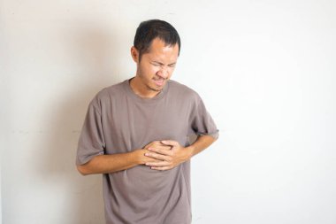 Genç erkekler izole edilmiş beyaz arka planda kalp krizi geçiriyor.