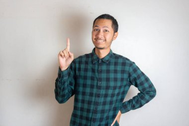 Genç erkekler, izole edilmiş beyaz arka planda işaret parmağıyla işaret ediyor.