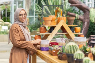 Küçük işletme sahibi kaktüs dükkanı gülen ve tesettürlü