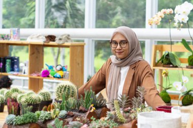 Küçük işletme sahibi kaktüs dükkanı gülen ve tesettürlü