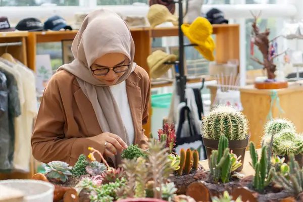 Küçük işletme sahibi kaktüs dükkanı gülen ve tesettürlü