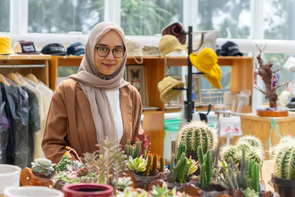 Küçük işletme sahibi kaktüs dükkanı gülen ve tesettürlü