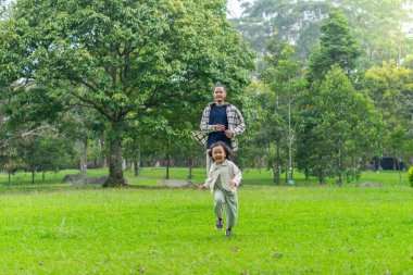 Babası ve kızı park bahçesinin dışında birlikte oynuyorlar.