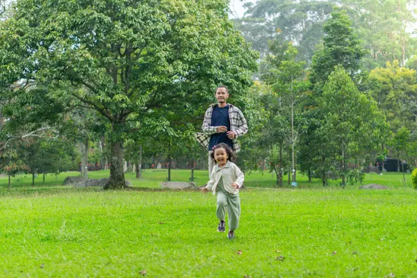 Babası ve kızı park bahçesinin dışında birlikte oynuyorlar.