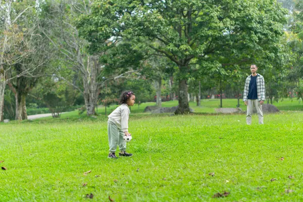 Babası ve kızı park bahçesinin dışında birlikte oynuyorlar.