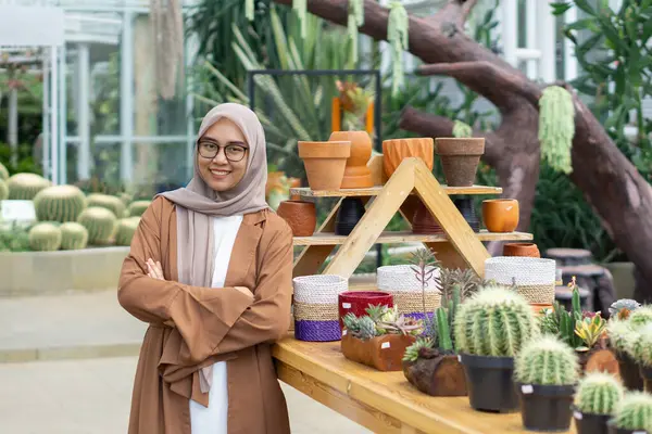 Küçük işletme sahibi kaktüs dükkanı gülen ve tesettürlü