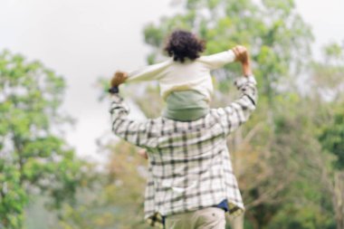 Baba ve kızının bahçedeki arka plandaki bulanık görüntüsü.