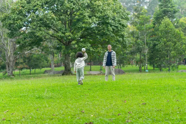 Babası ve kızı park bahçesinin dışında birlikte oynuyorlar.