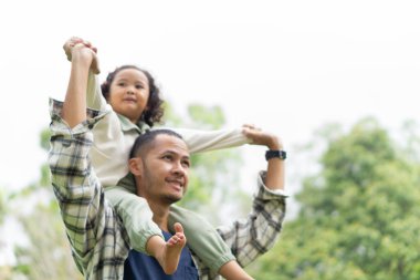 Baba ve kızının bahçedeki arka plandaki bulanık görüntüsü.