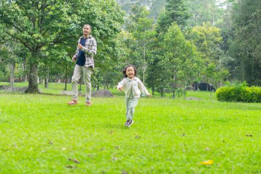 Babası ve kızı park bahçesinin dışında birlikte oynuyorlar.