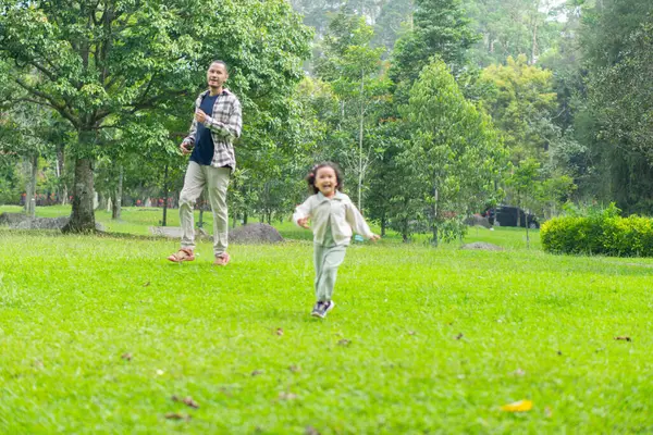 Babası ve kızı park bahçesinin dışında birlikte oynuyorlar.