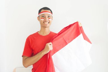 Endonezyalı genç adam, Endonezya bayrağını izole edilmiş beyaz bantla gösteriyor.