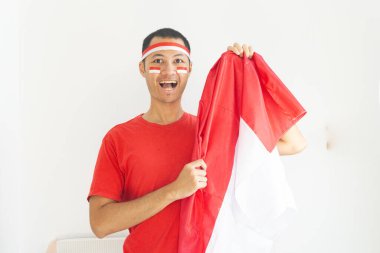 Endonezyalı genç adam, Endonezya bayrağını izole edilmiş beyaz bantla gösteriyor.