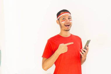 Endonezyalı genç adam, cep telefonunda izole edilmiş beyaz bantla işaret ediyor.