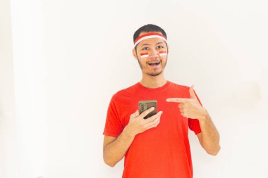 Endonezyalı genç adam, cep telefonunda izole edilmiş beyaz bantla işaret ediyor.