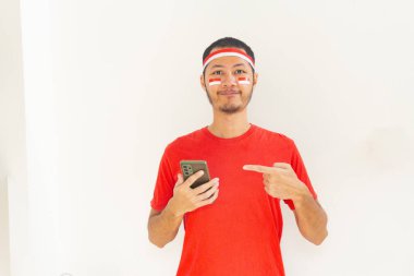 Endonezyalı genç adam, cep telefonunda izole edilmiş beyaz bantla işaret ediyor.