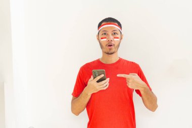 Endonezyalı genç adam, cep telefonunda izole edilmiş beyaz bantla işaret ediyor.