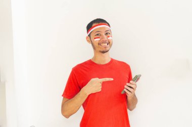 Endonezyalı genç adam, cep telefonunda izole edilmiş beyaz bantla işaret ediyor.