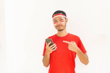 Endonezyalı genç adam, cep telefonunda izole edilmiş beyaz bantla işaret ediyor.