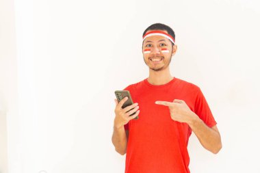 Endonezyalı genç adam, cep telefonunda izole edilmiş beyaz bantla işaret ediyor.