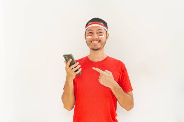 Endonezyalı genç adam, cep telefonunda izole edilmiş beyaz bantla işaret ediyor.