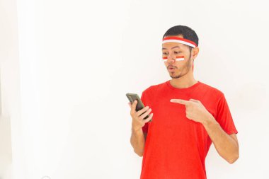 Endonezyalı genç adam, cep telefonunda izole edilmiş beyaz bantla işaret ediyor.