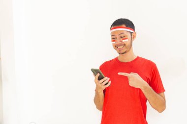 Endonezyalı genç adam, cep telefonunda izole edilmiş beyaz bantla işaret ediyor.