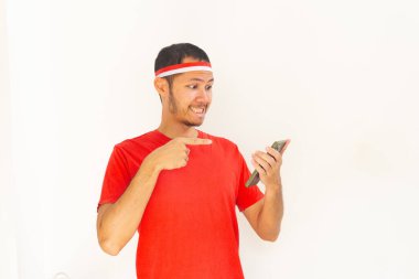 Endonezyalı genç adam, cep telefonunda izole edilmiş beyaz bantla işaret ediyor.