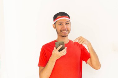 Endonezyalı genç adam, cep telefonunda izole edilmiş beyaz bantla işaret ediyor.