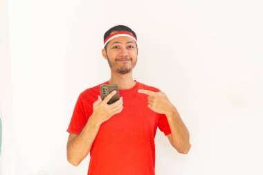 Endonezyalı genç adam, cep telefonunda izole edilmiş beyaz bantla işaret ediyor.